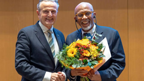 Professor Orlando Patterson receiving a bouquet of flowers.