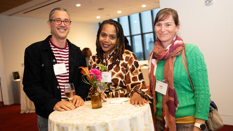 Three faculty members at a reception.