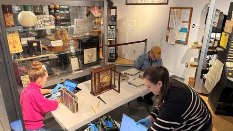 Group of people at a table examining scientific instruments.