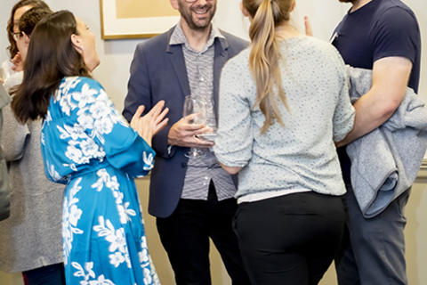 New faculty members and their guests in conversation at the reception.