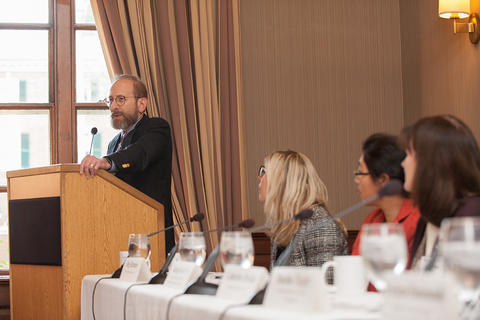 Provost Alan Garber stands at the podium to address the new faculty members.