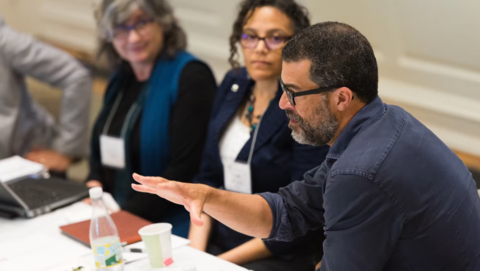 Three faculty members in discussion at a seminar.